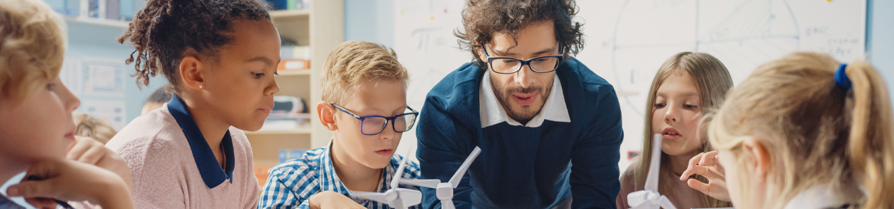 image banner of a group of young people in a classroom environment with a teacher